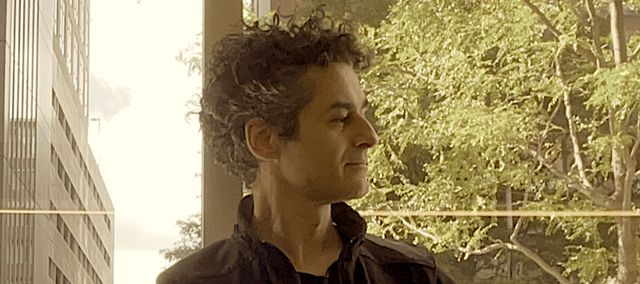 flow-b looking effortlessly cool while looking at a leaf his daughter is showing him in a coffee shop in Cambridge.